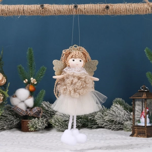 Handmade Christmas angel tree ornament with gold wings and tulle skirt in festive scenery