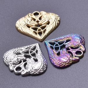 Macro detail of heart-shaped Celtic wolf pendants in gold, silver, and rainbow finishes
