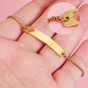 Gold stainless steel bar bracelet with heart cutout on adjustable box chain, hand-held view