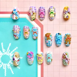 Macro shot of 3D bear nail charms with pink plaid patterns and pearl accents on nails