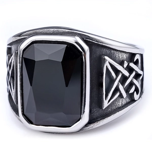 Macro shot of silver stainless steel ring with black rectangular gemstone and nordic carvings
