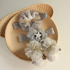 Detailed view of baby headband and socks set with lace bow and tulle pom-pom details