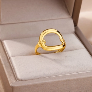 Macro detail of geometric horseshoe ring in 18k gold plating on beige velvet