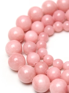 Vue macro de perles rondes en calcédoine rose polie pour la création de bijoux DIY
