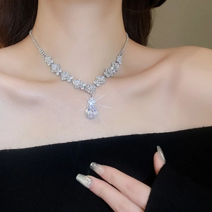 Close-up of elegant silver teardrop zircon necklace set worn on a model's neck