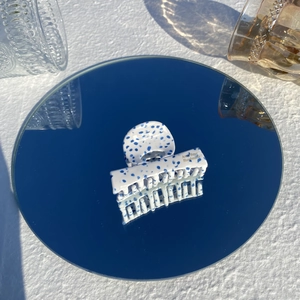 Minimalist marble pattern acetate hair claw clip with blue spots on reflective mirror