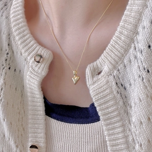 Close-up of a minimalist gold heart pendant necklace on a delicate O-chain for women