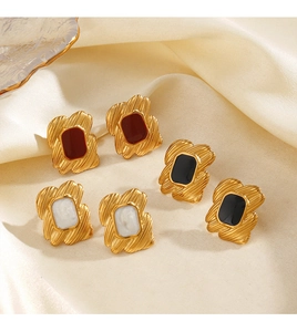 Detail of vintage geometric square stud earrings in gold with red black and white enamel