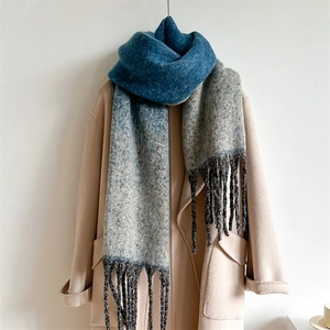 Close-up of blue-grey gradient scarf with speckled texture and fringed tassels detailing