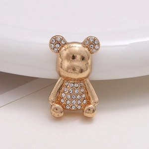 Detail of golden bear charm with inlaid rhinestones on a clean white surface