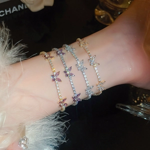 Dettaglio macro dei braccialetti a farfalla con zirconi scintillanti e cristalli di lusso