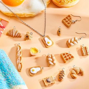 Resin food pendant jewelry set featuring croissant and waffle charms on peach background