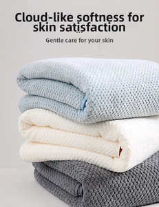 Close-up of three stacked towels in blue, white and grey showing honeycomb coral fleece texture