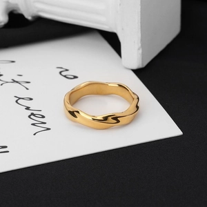 Detailed macro view of a gold-plated Mobius stainless steel ring with polished twisted band
