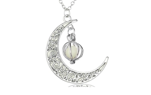 Detailed view of silver moon pendant with hollow pattern and glowing luminous bead