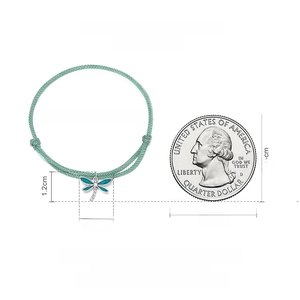 Size scale display of a 25cm adjustable teal woven dragonfly charm bracelet with 25c coin