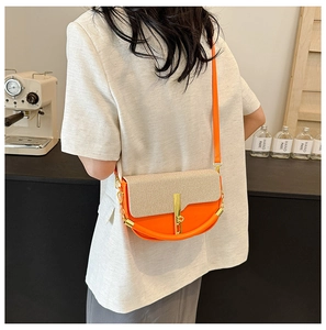 Detail of the dopamine color block crossbody bag with gold buckle on a white blazer