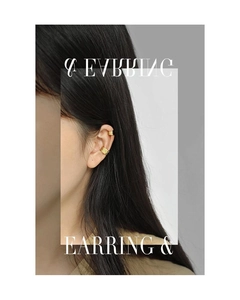 Detailed close-up of textured gold ear cuffs with a wavy brushed metal finish on model