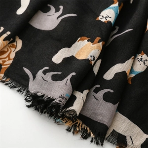 Detail of cartoon cat pattern on black scarf with soft texture and fringe edges