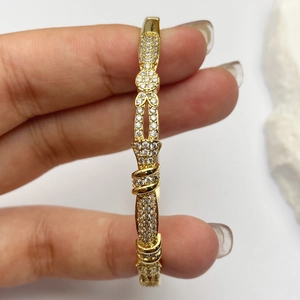 Bracciale aperto dorato chic con zirconi scintillanti incastonati per donna alla moda