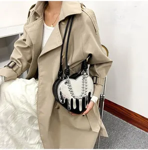 Detailed view of heart-shaped crossbody bag featuring liquid silver drop design and chain