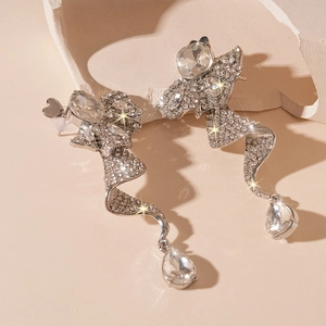 Detailed macro view of spiral silver earrings with sparkling crystals and teardrop pendants