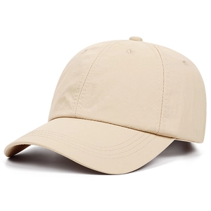 Detail view of the beige minimalist baseball cap showing curved brim stitching and texture