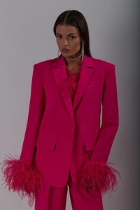 Detail of rose red blazer featuring ostrich feather cuffs and single-breasted button design