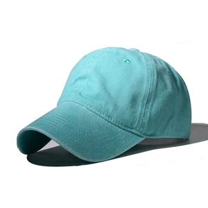 Detail showing the washed teal cotton fabric and texture of the plain baseball cap