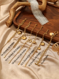 Detail view of gold-plated stainless steel bracelets with heart charms and toggle clasps