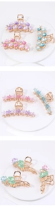 Close-up of alloy hair claws featuring gingko leaf and lotus designs with rhinestones