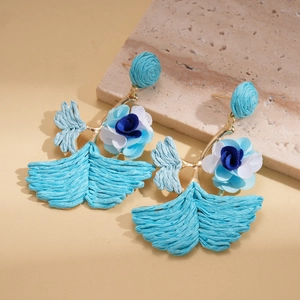 Detail of blue raffia flower earrings featuring woven texture and golden metal accents