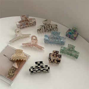 Flat lay of diverse acetate claw clips in marble, checkered and colorful patterns