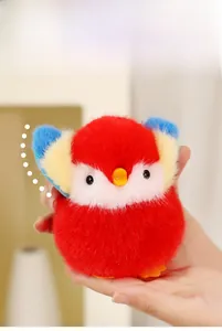 Gros plan d'un petit porte-clés oiseau en peluche rouge et bleu avec fourrure douce