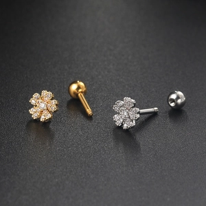 Detailed close-up of gold and silver flower zircon studs with screw back fasteners