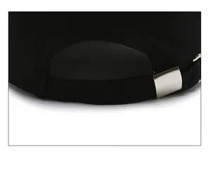 Close-up of adjustable metal buckle and strap on back of black baseball cap
