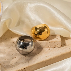 Minimalist 18K gold and silver chunky dome rings on a travertine stone surface
