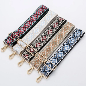 Adjustable ethnic patterned canvas bag straps with golden metal hooks on white background