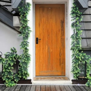 Outdoor festive decoration featuring two 180cm flocked snowy artificial pine garlands on a door