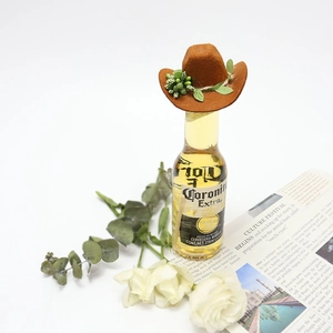 Miniature brown felt cowboy hat with greenery and twine on a small beer bottle decoration