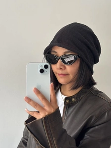 Close-up of a premium black linen slouchy beanie paired with vintage cat-eye sunglasses