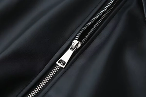 Close-up of high-quality silver metal zipper on black vintage PU leather jacket