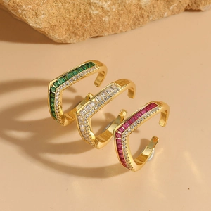 Three V-shaped 14K gold-plated rings with red, green and clear zircon stones on rocks
