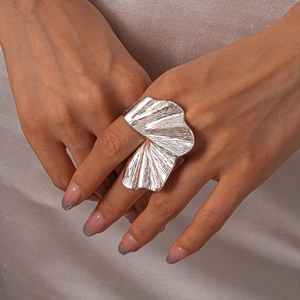 Detailed shot of large silver flower statement ring with pleated texture and metallic luster