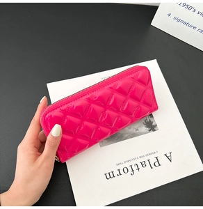 Detail of rose pink quilted patent leather long wallet with a secure zipper closure