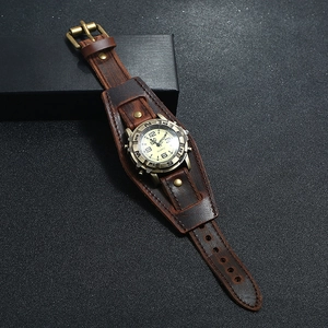 Vintage brown leather punk watch with bronze metal case on a black textured surface