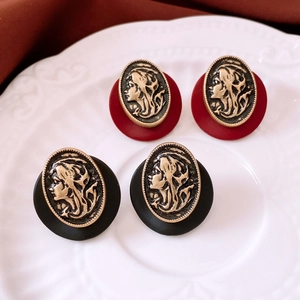 Detailed view of French vintage cameo earrings with red and black resin oval bases