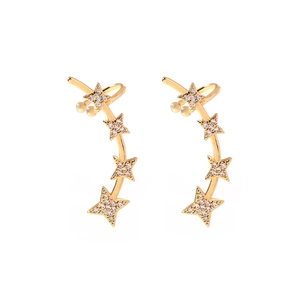 Close-up of golden star ear cuff earrings featuring five sparkling rhinestones on white background