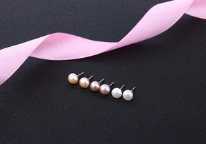 Detailed close-up of three pairs of S925 silver freshwater pearl earrings on black background