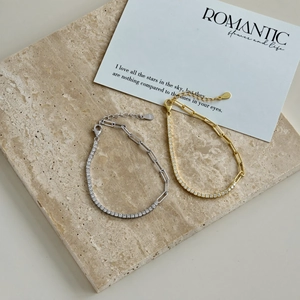 Detail of S925 sterling silver tennis and paperclip chains with gold and silver finishes